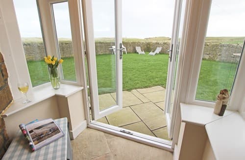 Pretty gardens with stone walls and fields beyond