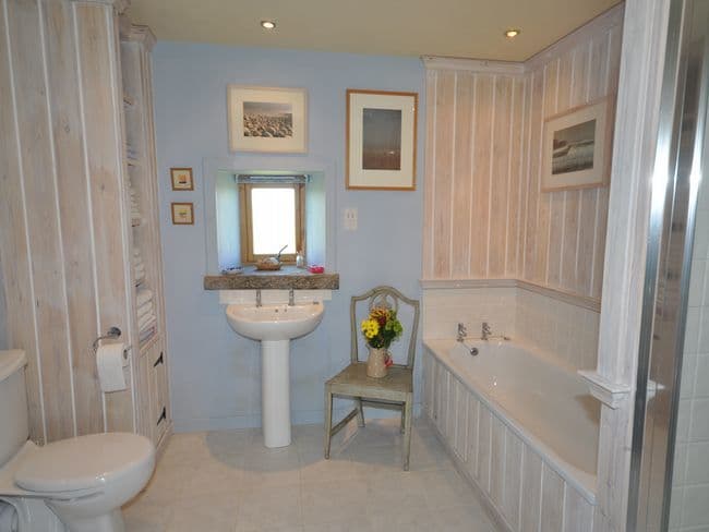 Spacious bathroom with bath and shower cubicle