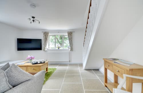 The warm and comfortable living room has a large Smart TV and picture window
