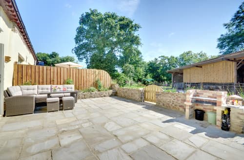 The private paved patio area with relaxed seating, table and barbecue
