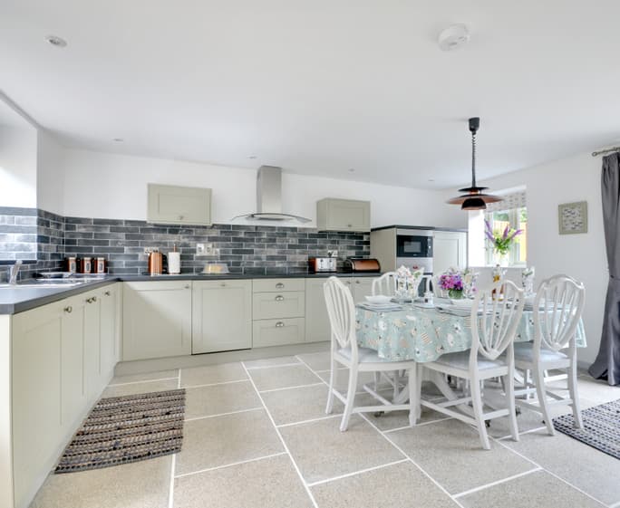 The well equipped kitchen has plenty of room and French doors which lead out to the private paved patio area