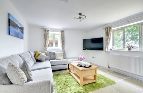 The warm and comfortable living room has a large Smart TV and picture window