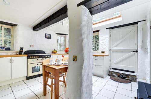 The kitchen with breakfast table, butler sink and  electric woodburner