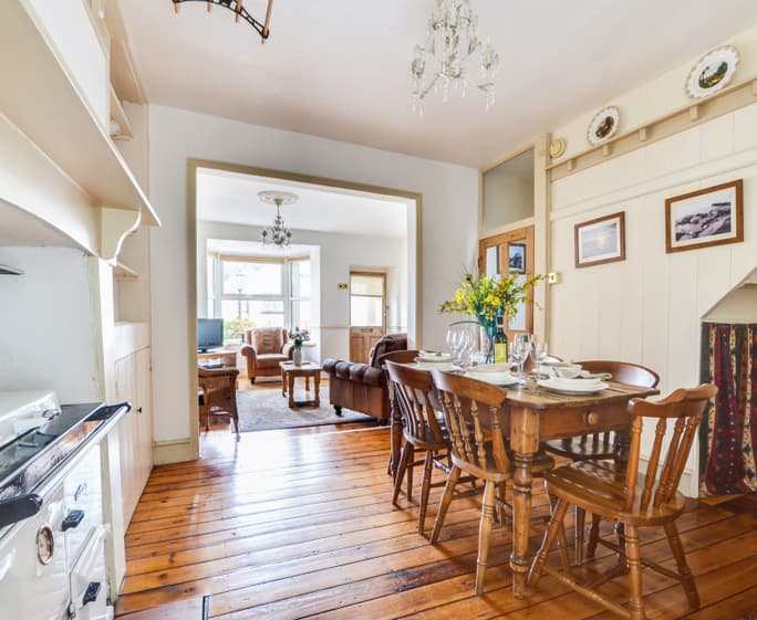 The dining room features a Rayburn and country style dining table and chairs