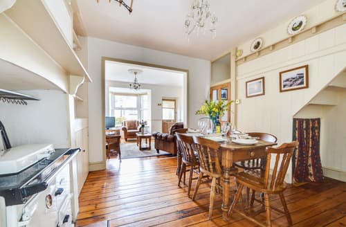 The dining room features a Rayburn and country style dining table and chairs
