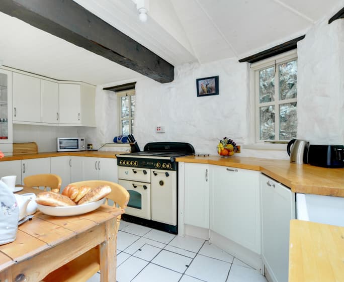 The attractive shaker style breakfast kitchen features oak beams and butler sink