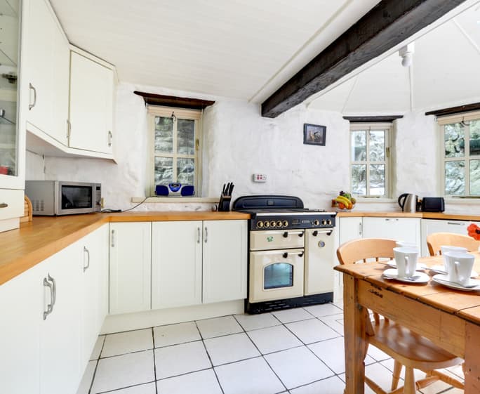 The attractive shaker style breakfast kitchen features oak beams and butler sink