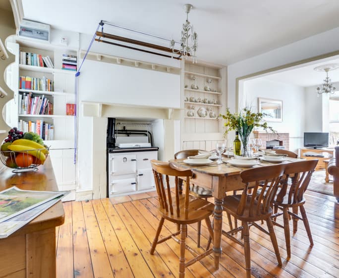 The dining room features a Rayburn and country style dining table and chairs