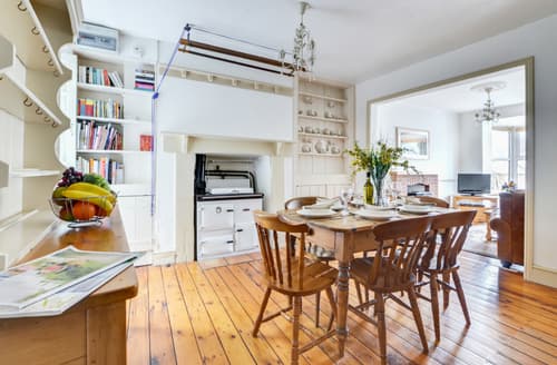The dining room features a Rayburn and country style dining table and chairs