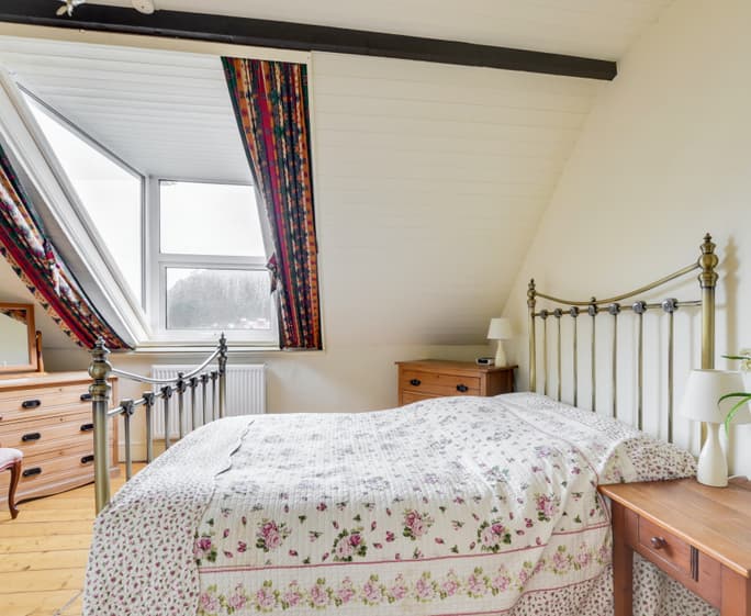 The stylish master bedroom on the second floor enjoys wonderful sea views in one direction and beautiful countryside views in the other 